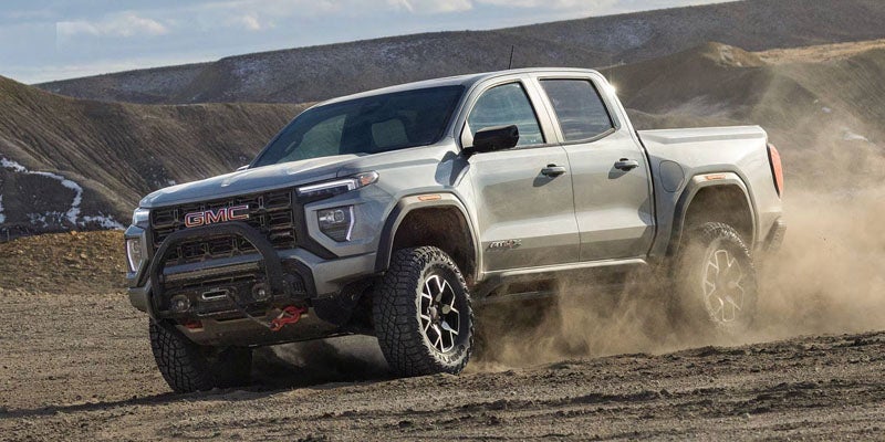 2026 GMC Canyon driving through rugged terrain highlighting superior off-road capability and performance